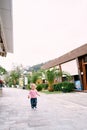 Little girl walking on the pavement of the resort town Royalty Free Stock Photo