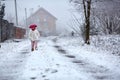 Little girl walking on snowy rural road Royalty Free Stock Photo