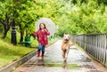 Little girl walking under rain with dog Royalty Free Stock Photo