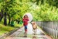 Little girl walking under rain with dog Royalty Free Stock Photo