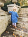 little girl walking up steps in the fall