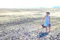 Little girl walking on a deserted field