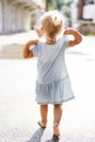 Little girl walks barefoot through the puddles. Back view Royalty Free Stock Photo