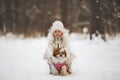 Beautiful little girl with her dog on the snow in winter