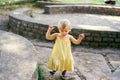 Little girl walks near a semicircular retaining stone wall Royalty Free Stock Photo