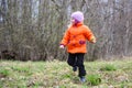 Little girl walks outdoors. Happy child in countryside. Early spring.