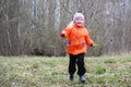 Little girl walks outdoors. Happy child in countryside. Early spring.