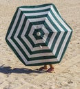 Little girl walks under old beach umbrella. Fun Royalty Free Stock Photo