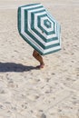 Little girl walks under old beach umbrella. Fun Royalty Free Stock Photo