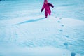Little girl walks in winter nature leaving steps in snow Royalty Free Stock Photo
