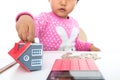 The little girl was fiddling with the coins on the table, the model of the small house and a calculator Royalty Free Stock Photo