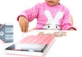 The little girl was fiddling with the coins on the table, the model of the small house and a calculator Royalty Free Stock Photo