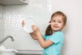The little girl washes the dishes