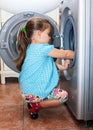 Little girl washing clothes in the machine Royalty Free Stock Photo