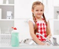 Little girl washing dishes in the kitchen Royalty Free Stock Photo