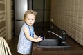 Little girl washing dishes in the kitchen at home