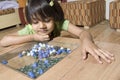 Little girl watch glass marbles Royalty Free Stock Photo