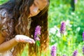 little girl watching a bee pollinate wild flowers in a field Royalty Free Stock Photo