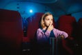Little girl watching a film at a movie theater