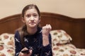 Little girl is watching tv in her bed. Little girl watching tv. Teen girl eating popcorn in front of the TV. toned Royalty Free Stock Photo