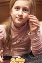 Little girl is watching tv in her bed. Little girl watching tv. Teen girl eating popcorn in front of the TV. toned. vertical photo Royalty Free Stock Photo