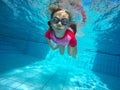 The little girl in the water park swimming underwater and smiling Royalty Free Stock Photo