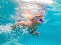 The little girl in the water park swimming underwater and smiling Royalty Free Stock Photo