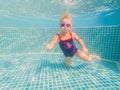 The little girl in the water park swimming underwater and smiling Royalty Free Stock Photo