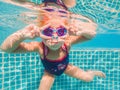 The little girl in the water park swimming underwater and smiling Royalty Free Stock Photo