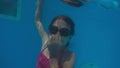 The little girl in the water park swimming underwater and smiling Royalty Free Stock Photo