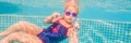 The little girl in the water park swimming underwater and smiling BANNER, LONG FORMAT Royalty Free Stock Photo