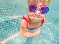 The little girl in the water park swimming underwater and smiling Royalty Free Stock Photo