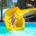 Little girl on water slide at aquapark during