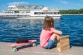 Little girl on the waterfront. Walk on the boat. Sunny summer day Royalty Free Stock Photo