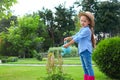 Little girl watering flowers in backyard Royalty Free Stock Photo