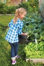 Little girl watering the flowers in the family garden Royalty Free Stock Photo