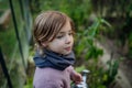 Little girl watering plants in garden, using collected rainwater. Concept of water conservation in garden and family