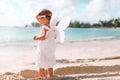 Beautiful young girl wearing angel wings on the beach Royalty Free Stock Photo