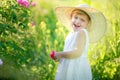 A little girl wearing flower yellow dress with white hat and stand in the yellow flower field of Sunn Hemp Crotalaria Royalty Free Stock Photo