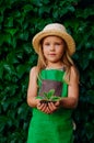 Little girl wearing the green apron holding sprout Royalty Free Stock Photo