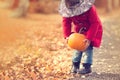 Little girl wearing Halloween witch hat and warm red coat, having fun in autumn day. Royalty Free Stock Photo