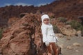 The child is sitting on a mountain of sand. Blue sky. A little g Royalty Free Stock Photo