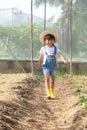 Little girl wearing a hat helps her mother in the garden, a little gardener. Cute girl playing in the vegetable garden Royalty Free Stock Photo