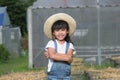 Little girl wearing a hat helps her mother in the garden, a little gardener. Cute girl playing in the vegetable garden Royalty Free Stock Photo