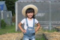 Little girl wearing a hat helps her mother in the garden, a little gardener. Cute girl playing in the vegetable garden Royalty Free Stock Photo