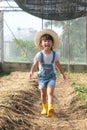 Little girl wearing a hat helps her mother in the garden, a little gardener. Cute girl playing in the vegetable garden Royalty Free Stock Photo