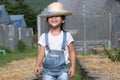 Little girl wearing a hat helps her mother in the garden, a little gardener. Cute girl playing in the vegetable garden Royalty Free Stock Photo