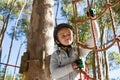 Little girl wearing helmet getting ready to climb on rope fence Royalty Free Stock Photo