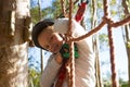 Little girl wearing helmet standing on rope fence Royalty Free Stock Photo