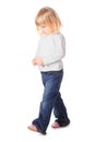 Little girl wearing jeans and shirt is walking